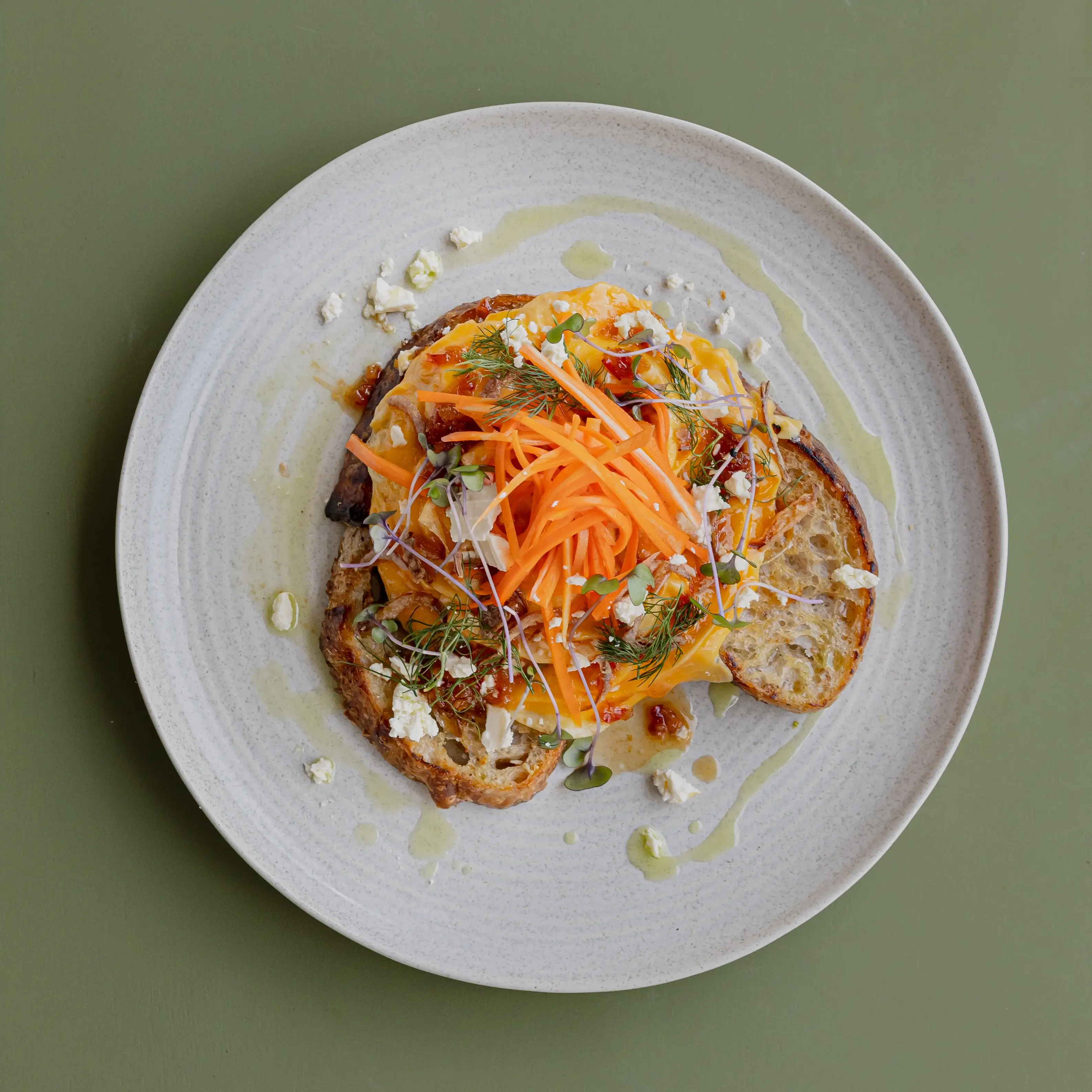 Chilli scrambled eggs, feta cheese, fried shallots, pickled carrots, herb puree